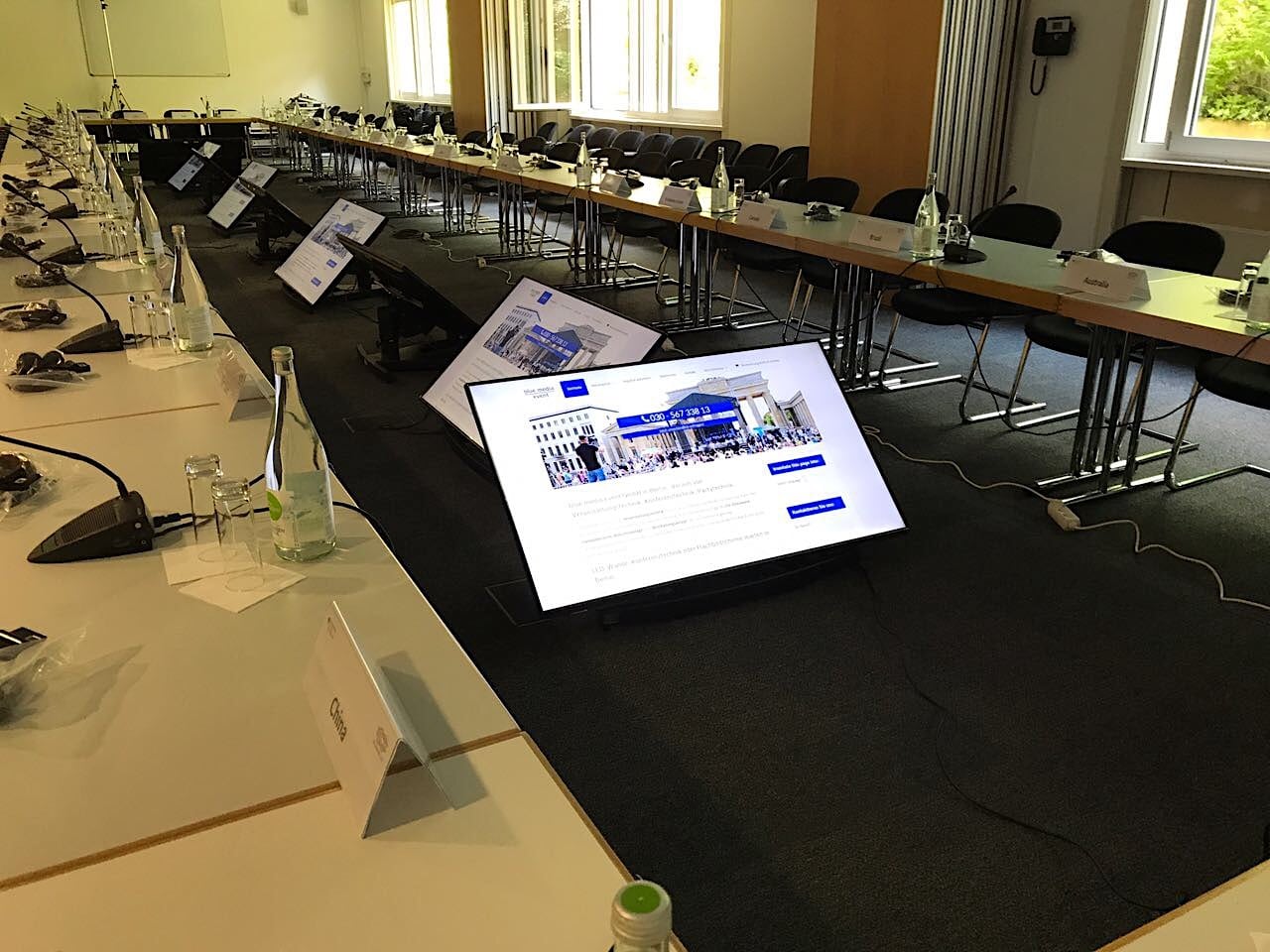 Flachbildschirme und eine Mikrofonkette Mikrofonanlage für eine round table Diskussion