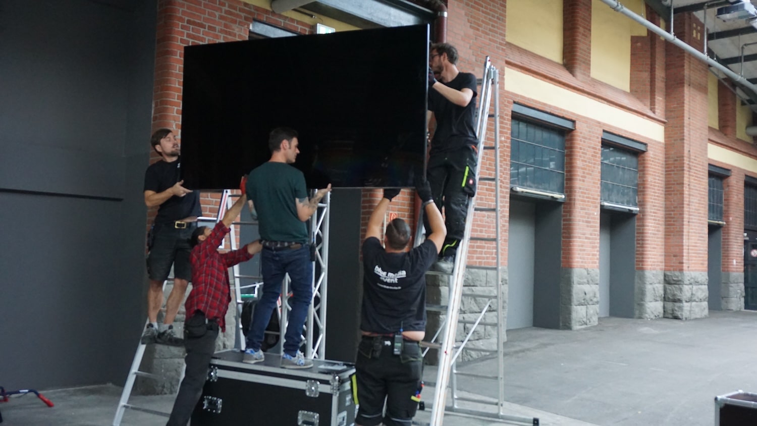 ein Bildschirm mit 95 Zoll Bildschirmdiagonale wird vom Team der blue media an einem Traversen-Ständer angebracht