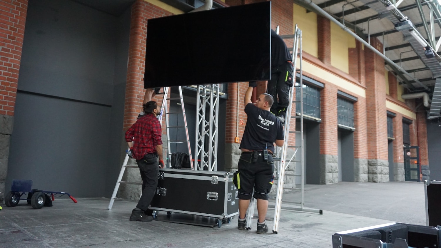 ein Bildschirm mit 95 Zoll Bildschirmdiagonale wird vom Team der blue media an einem Traversen-Ständer montiert