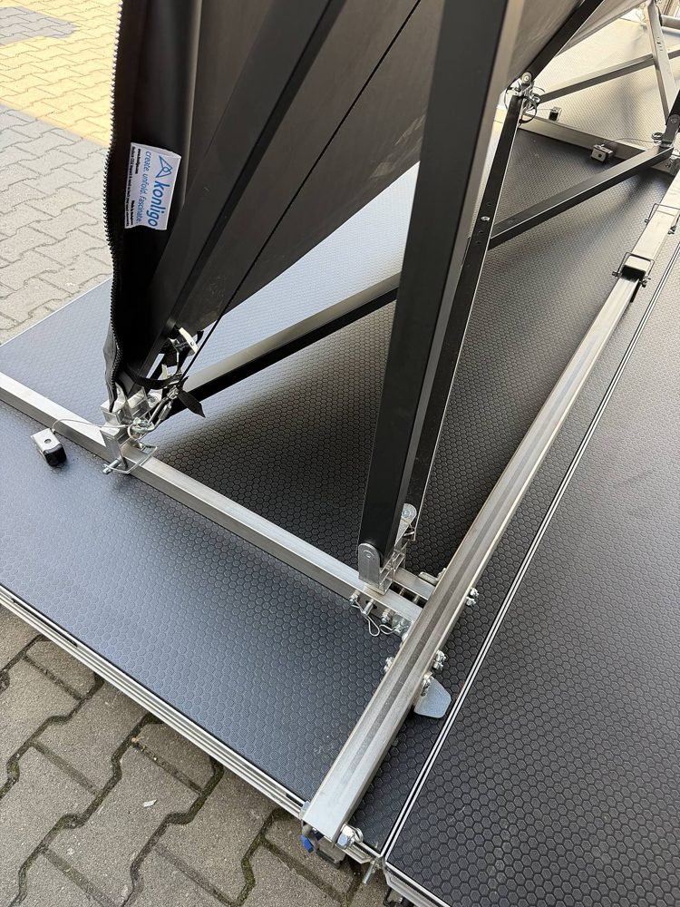 Verbindungssystem Detail 1 Verbindungssystem zwischen Rundbogendach und Bühnenplatte, Detailansicht der verschraubten Fußplatte